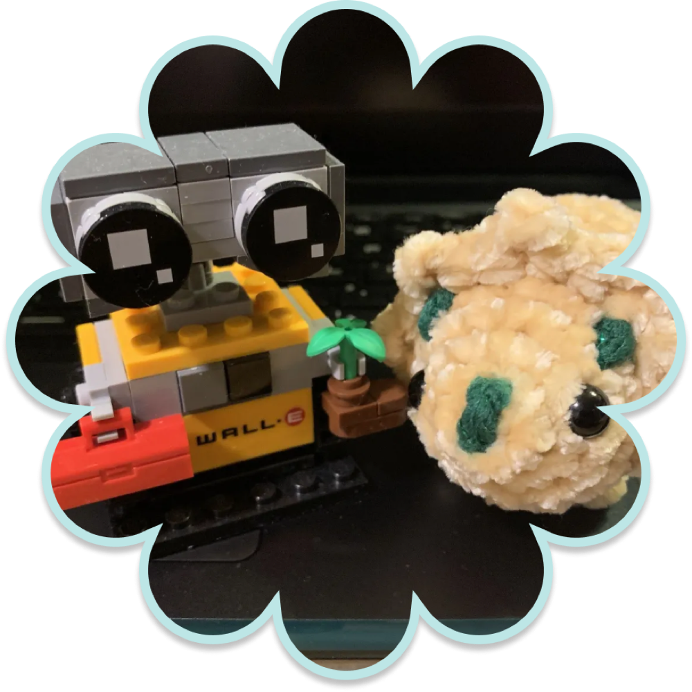 A plush dino next to a small WALL-E building set