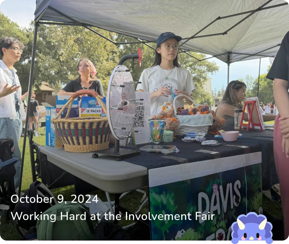 October 9, 2024 — Working Hard at the Involvement Fair: members running the club booth with a prize wheel and baskets of crocheted dinos.